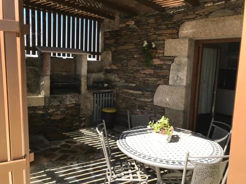 a white table and chairs on a patio at Refúgio dos Macedos in Bilhó