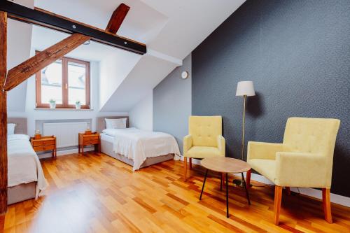 a bedroom with two beds and a table and two chairs at Atticus in Kraków