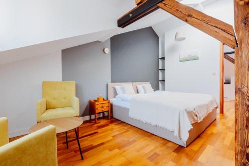 een slaapkamer met een bed en een stoel bij Atticus in Krakau