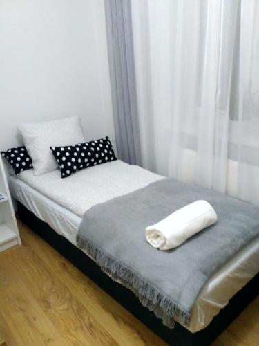 a bed with a white towel on top of it at Apartament UnoPuro w centrum in Chełm