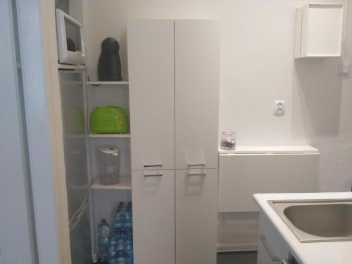 una cocina con armarios blancos y fregadero en Apartament UnoPuro w centrum, en Chełm