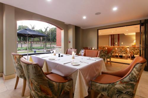 a dining room with a white table and chairs at The Rasmus in Pretoria