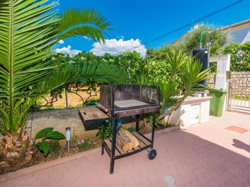 - un barbecue installé dans un jardin avec des plantes dans l'établissement Apartments Trogrlic, à Privlaka