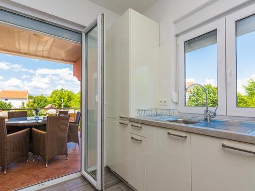 une cuisine avec un évier et une vue sur un patio dans l'établissement Apartments Trogrlic, à Privlaka