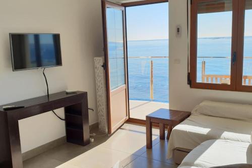 a living room with a couch and a tv and a window at Paseo Playa de los Estudiantes in Villajoyosa