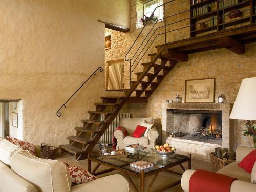 a living room with a staircase and a fireplace at Borgo di Pianciano in Spoleto
