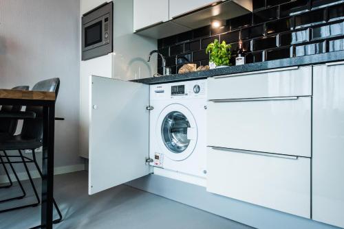 a white laundry room with a washer and dryer at Amsterdam East by YAYS in Amsterdam