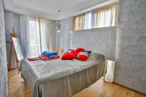1 dormitorio con 1 cama con almohadas rojas y azules en New Wave, en Grigoleti