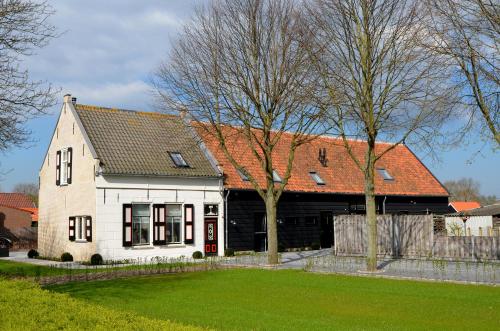 ein großes weißes Haus mit orangefarbenem Dach in der Unterkunft De Meulestee in Ouddorp