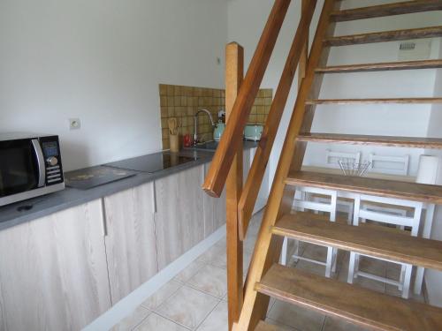 a kitchen with a ladder leading up to a microwave at Domaine La Synchronicité - Gîte et Chambres d'Hôtes in Vaudrimesnil