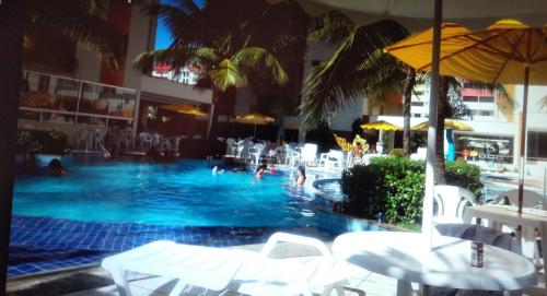a swimming pool with people in a hotel at APARTAMENTO JARDINS DAS THERMAS CALDAS NOVA in Caldas Novas