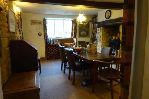 a kitchen and dining room with a table and chairs at Wheelwrights in Abbotsbury