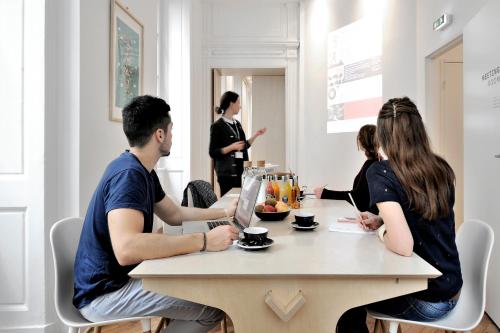 a group of people sitting at a table in a room at SLO Hostel Lyon les Pentes in Lyon