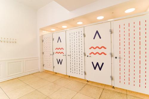 a room with white walls and a row of lockers at SLO Hostel Lyon les Pentes in Lyon