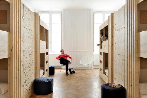 
a person standing in a room with a suitcase at Away Hostel & Coffee Shop in Lyon
