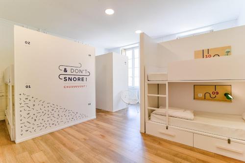 a room with two bunk beds in a room with wooden floors at SLO Hostel Lyon les Pentes in Lyon