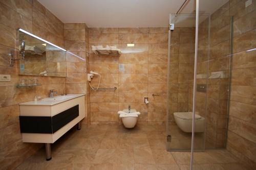 a bathroom with a sink and a toilet and a shower at Hotel Villa Radin in Vodice