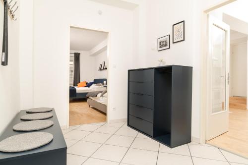 a living room with a black dresser and a bedroom at Zum Grazer Uhrturm in Graz