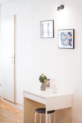 a white desk in a white room with a stool at Zum Grazer Uhrturm in Graz