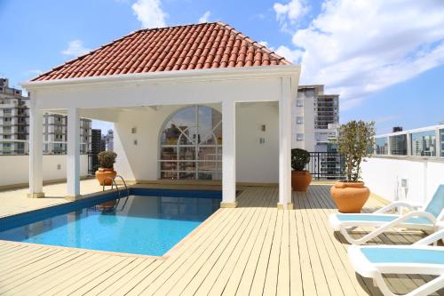 a swimming pool with a gazebo on top of a building at Vitória Hotel Residence NewPort in Campinas