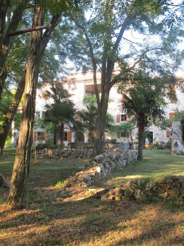 a stone wall in front of a house with trees at Villa Castello Rausch in Poreč