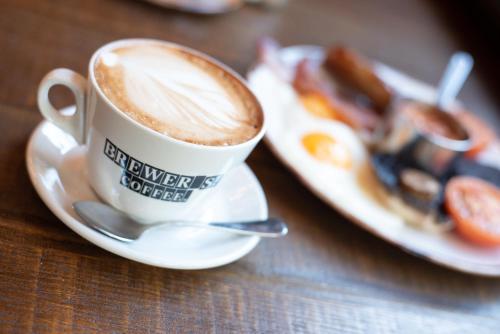 a cup of coffee next to a plate of food at Counting House in London