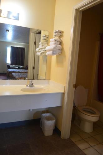 a bathroom with a sink and a toilet and a mirror at Ouachita Mountain Inn in Glenwood