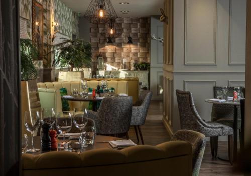 a restaurant with tables and chairs with wine glasses at Ramada Hotel & Suites by Wyndham Coventry in Coventry