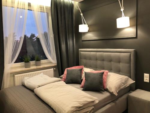 キェルツェにあるFamily & Business Sauna Apartments No 4 Leśny nad Zalewem Cedzyna - 2 Bedroom with Private Sauna, Bath with Hydromassage, Terrace, Parking, Catering Optionsのベッド1台(枕2つ付)、窓が備わります。