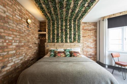 um quarto com uma parede de tijolos e uma cama em One Broad Street em Brighton & Hove