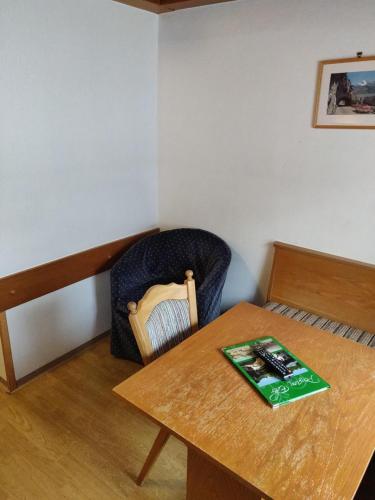 a room with a table and a chair with a book on it at Pension Eder - Joker card included in summer in Saalbach Hinterglemm