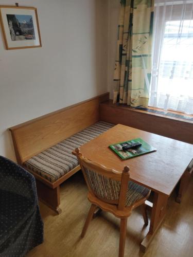 a small room with a bench with a table and a window at Pension Eder - Joker card included in summer in Saalbach Hinterglemm