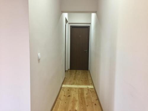an empty hallway with a wooden floor and a door at Guest House Maradona in Sighnaghi