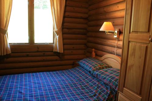 a bedroom with a bed in a wooden room at Highgarry Lodges in Invergarry