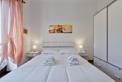 una camera da letto con un grande letto bianco con due lampade di Vanchiglietta Colourful Apartment a Torino