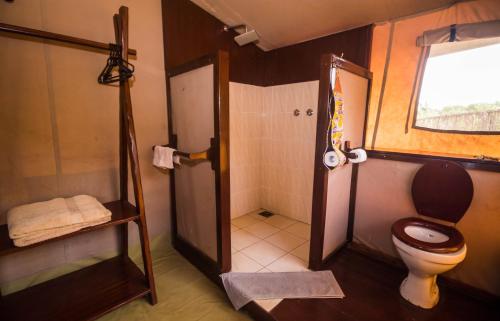 a bathroom with a toilet and a shower at Oldarpoi Wageni Camps in Keekorok