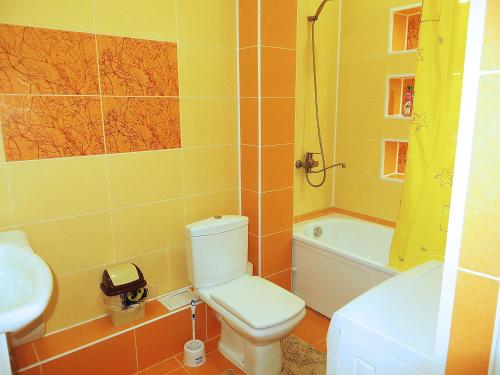 een badkamer met een toilet, een wastafel en een bad bij Comfort Apartment in Bisjkek