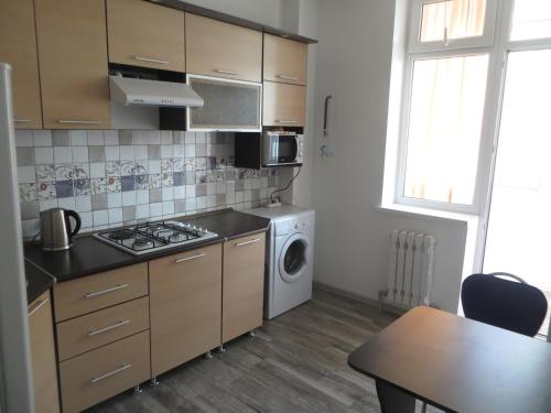 una cocina con estufa y lavadora en Comfort Apartment, en Bishkek