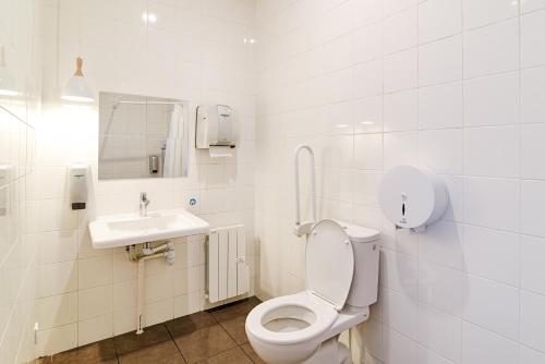 a white bathroom with a toilet and a sink at SLO Hostel Lyon Saxe in Lyon