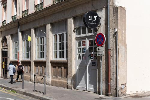 a building with a sign on the side of a street at SLO Hostel Lyon Saxe in Lyon