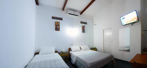 タラポトにあるHostal Casa Blancaのベッド2台と薄型テレビ付きの部屋