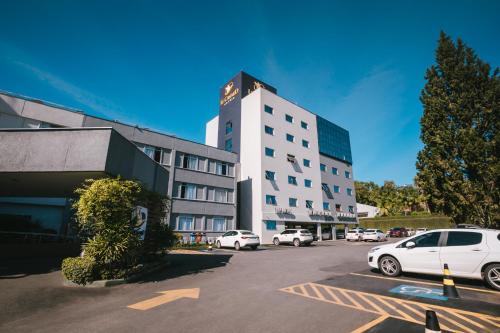 a white car parked in a parking lot in front of a building at Le CanarD Joinville in Joinville