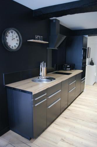 une cuisine avec un évier et une horloge murale dans l'établissement Le 1777, à Dinan