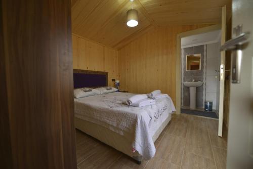 a bedroom with a bed and a bathroom with a sink at Marbella Kale Beach in Akçakale
