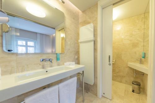 a bathroom with a sink and a mirror at Hotel Jakubus in Wilków
