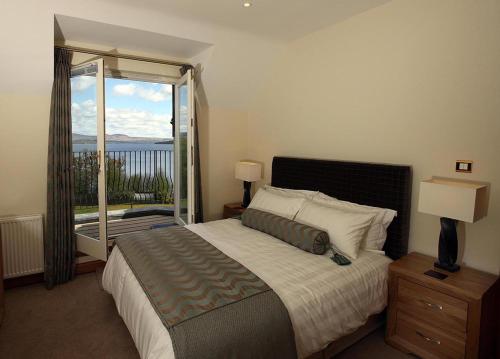 a bedroom with a large bed and a large window at No 15 Lomond Castle in Balloch