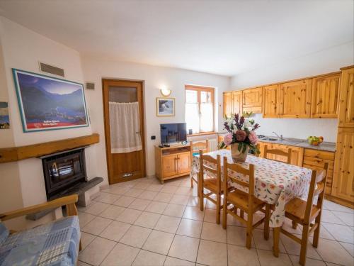 eine Küche mit einem Tisch und Stühlen sowie einem Kamin in der Unterkunft Chalet village situated in a quiet area in Antey-Saint-André
