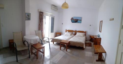 a bedroom with a bed and a table and chairs at Sunset in Kalymnos