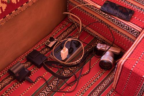 a red suitcase with a camera and a camera charger at Arabian Nights in Wadi Rum
