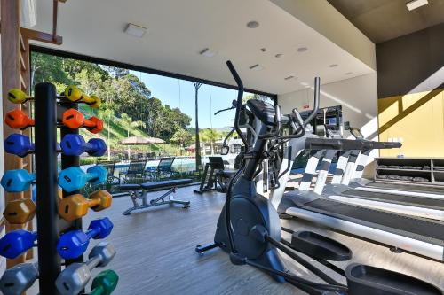 a fitness room with a gym with tread machines at Quality Hotel Blumenau in Blumenau